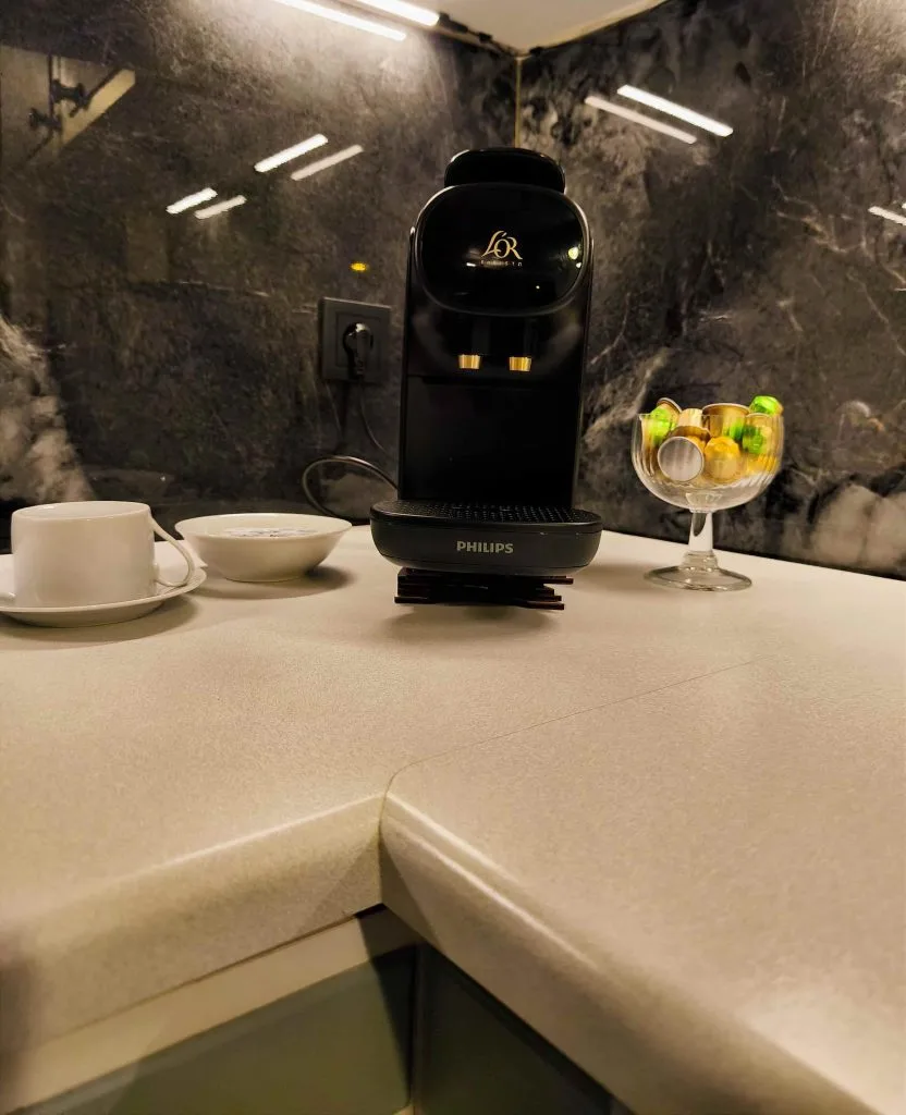 Kaffeemaschine mit Tasse und Glas auf der Arbeitsplatte der Ferienwohnung Burgperle