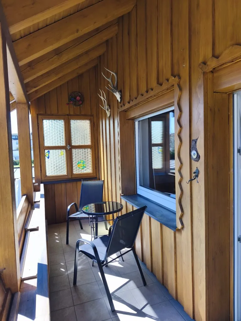 Balkon der Ferienwohnung Burgperle mit Holzverkleidung, Tisch und Stuhl