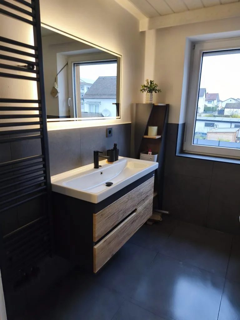 Badezimmer der Ferienwohnung Burgperle mit Waschtisch, Spiegel und Fenster