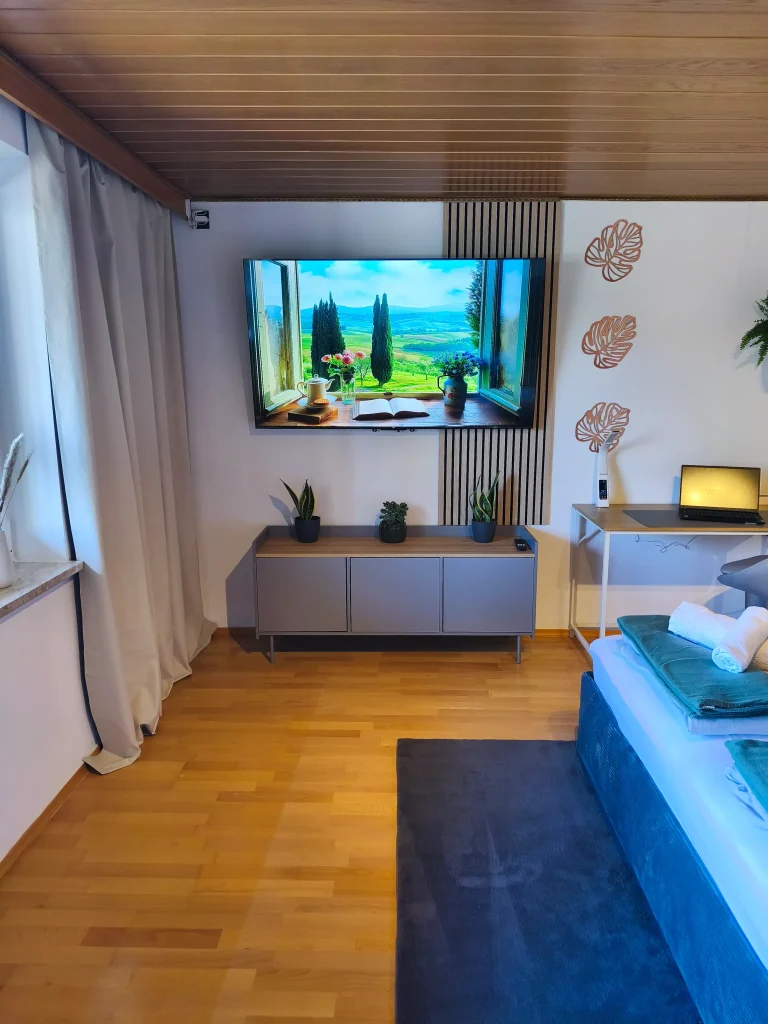Wohnbereich der Ferienwohnung Burgperle mit Fernseher auf dem Sideboard
