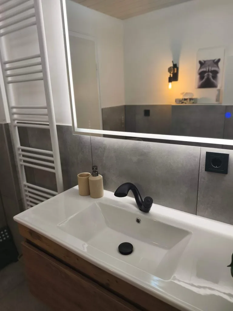 Badezimmer der Ferienwohnung Burgjuwel mit Waschtisch, großem Spiegel und Handtuchheizkörper