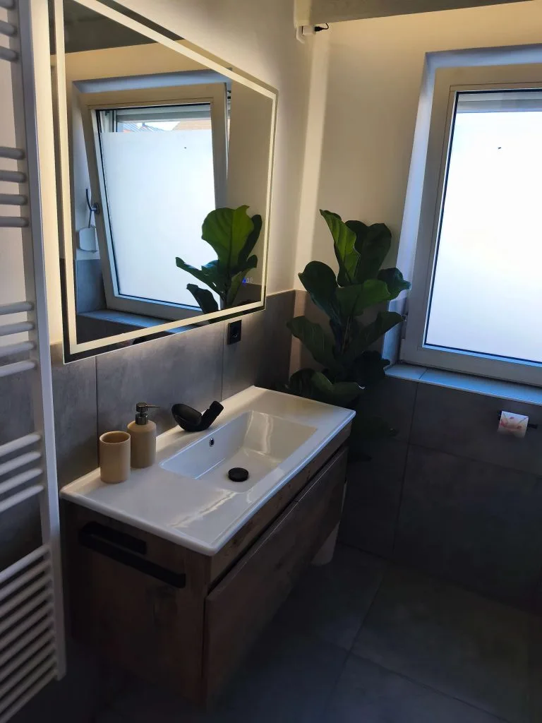 Waschtisch mit beleuchtetem Spiegel im Badezimmer der Ferienwohnung Burgjuwel