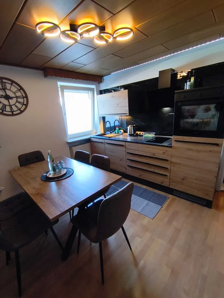 Essplatz und Küchenzeile der Ferienwohnung Burgjuwel unter Holzdecke