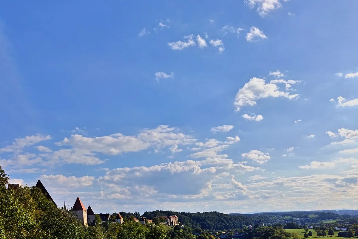 Burgmauern von Burghausen über dem Wöhrsee, dahinter das weite Salzachtal