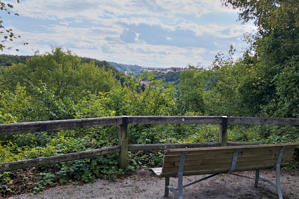 Holzbank an einem Geländer mit Blick über das Salzachtal